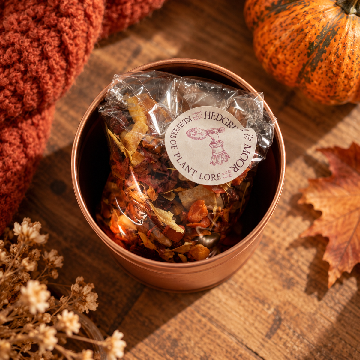 A packet of hedgerow and moor spiced pumpkin botanical tea in a rose gold tin