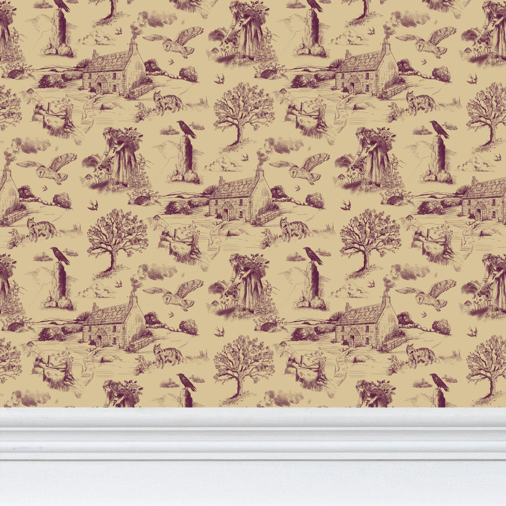 A repeating toile-style wallpaper pattern in muted plum purple on a warm beige background, shown above a white baseboard. The print features Cornish countryside motifs including trees, cottages, birds, and animals.