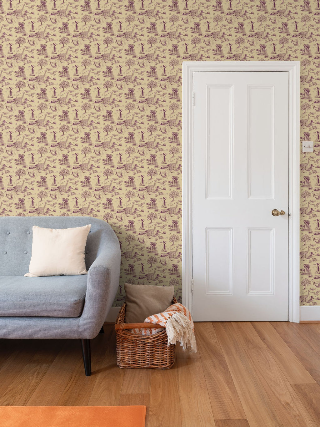 Living room with Toile du jouy Cornish wallpaper, gray sofa, and wooden floor.