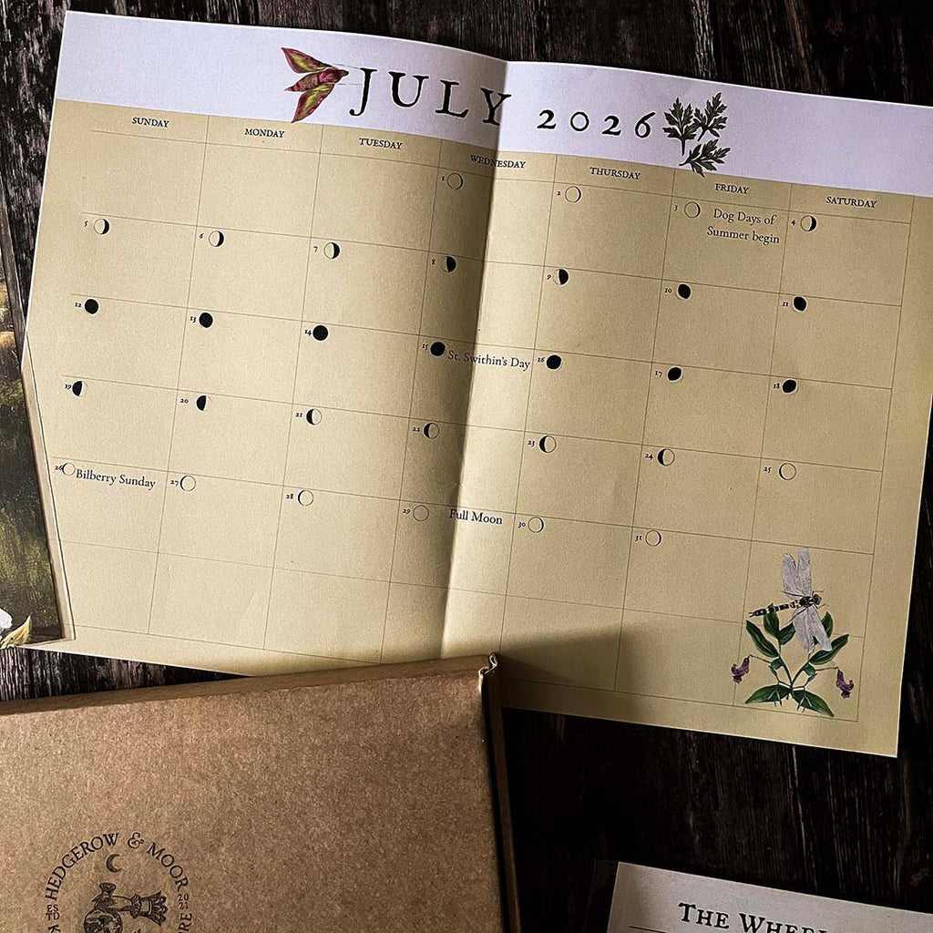 Hedgerow and Moor moon phase Calendar for July 2026 with botanical illustrations on a wooden surface.