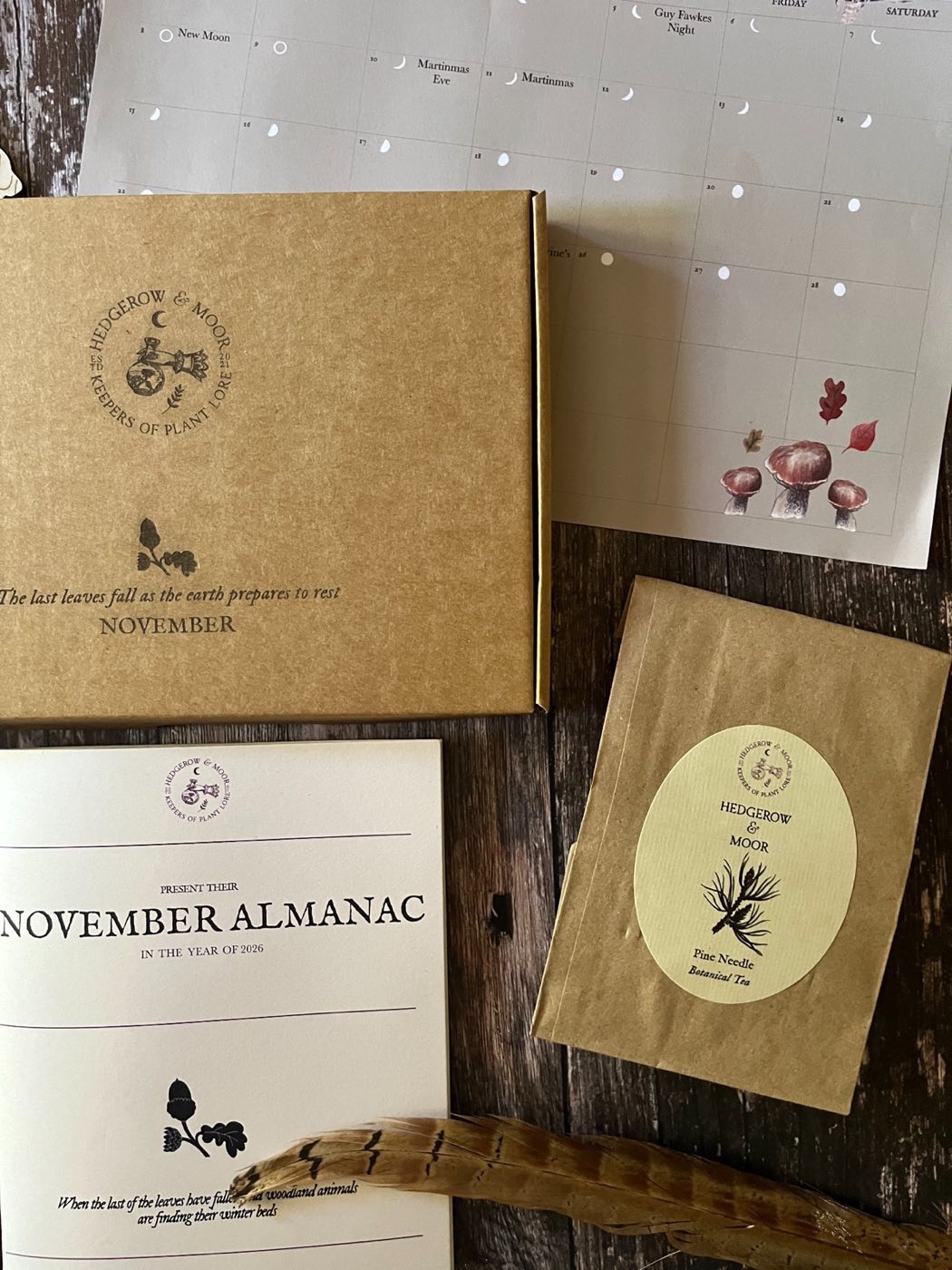 Close-up of the November Almanac box, Pine Needle Botanical Tea packet, zine cover and illustrated calendar.