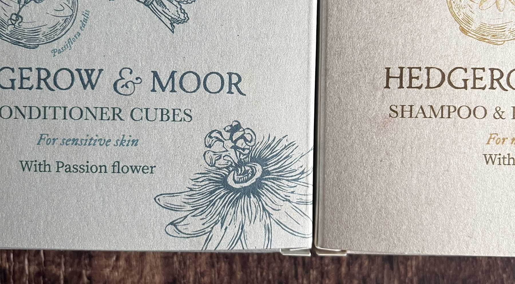 Two boxes of Hedgerow & Moor hair care products on a wooden surface.